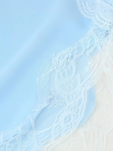 Detailed close-up of light blue fabric texture with elegant white lace trim detailing