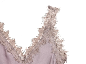Detail eines seidigen Kleides in Mauve mit feiner Wimpernspitze und verdecktem Reißverschluss