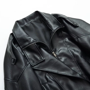 Detail of black faux leather jacket collar with buttoned epaulettes and silver zipper