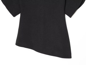 Detail showing the unique asymmetrical hem design and woven fabric of the black top