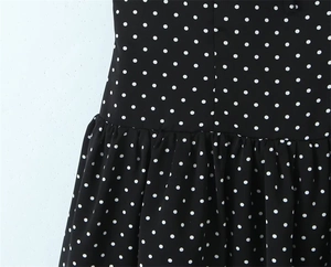 Detailed macro view of black polka dot fabric with pleated texture and fine stitching
