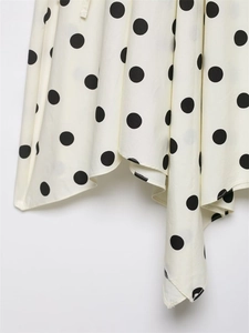 Détail du tissu blanc à pois légers avec ourlet irrégulier et coutures de haute précision