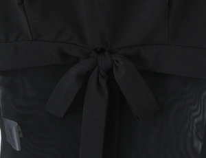 Détail de la robe en maille noire avec un nœud à lacets délicat et texture de tissu voile