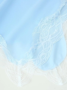 Detailed view of elegant light blue fabric with intricate white floral lace trim details