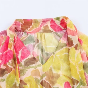 Detail of elegant V-neckline with abstract watercolor floral print on chiffon fabric