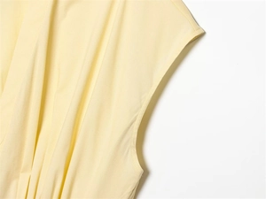 Detail view of light yellow poplin dress featuring subtle pleats and high-quality stitching