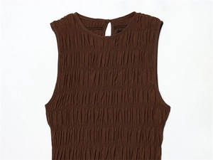 Detail of brown smocked sleeveless dress showing ruffled texture and back button closure
