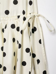 Détail d'une jupe mi-longue à pois avec ceinture nouée et tissu plissé élégant