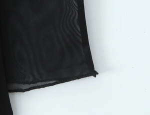 Détail macro du tissu en maille noire respirante avec texture fine et finitions