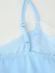 Detail of adjustable strap and white lace trim on a light blue fashion camisole top