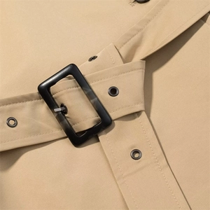 Detail of khaki trench coat waist belt featuring twill fabric and marble resin buckle