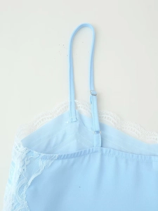 Detail of light blue camisole top featuring white eyelash lace trim and adjustable straps