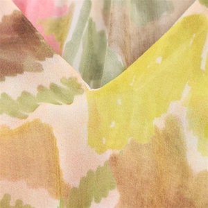 Detailed macro view of V-neckline and watercolor floral print on chiffon fabric