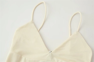 Detail of a beige asymmetric camisole top with ultra-thin straps and a sleek V-neckline