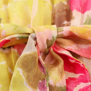 Detail of vibrant floral print fabric featuring a decorative bow tie and clean stitching