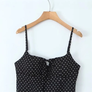 Retro black polka dot camisole with thin straps and delicate bow detail on the neckline