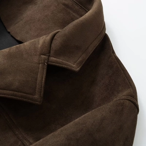 Close-up of dark brown suede texture and neat shoulder stitching on a blazer coat
