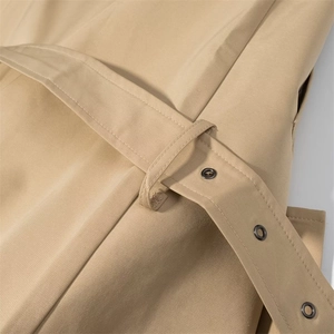 Detail of khaki trench coat with metal eyelet belt and high-quality twill fabric texture