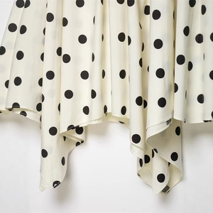 Jupe mi-longue asymétrique élégante à pois en tissu léger avec un drapé fluide