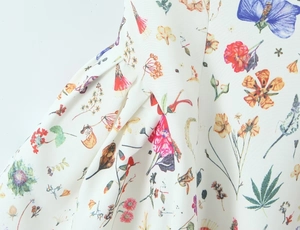 Detailed view of floral print fabric with pleats on a summer strap dress for women