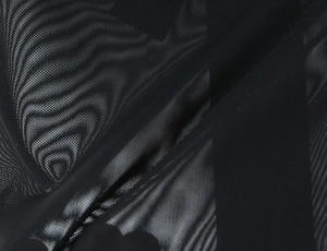 Gros plan sur le tissu en maille noire avec texture alvéolée respirante et transparence