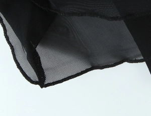Gros plan sur un tissu en maille noire montrant la texture fine et les coutures du bord