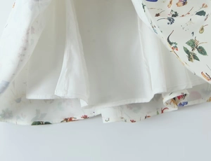 Detail of floral dress hem showing fine stitching and soft white inner lining texture
