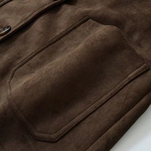 Detail of dark brown faux suede blazer showing stitching on pocket and amber button