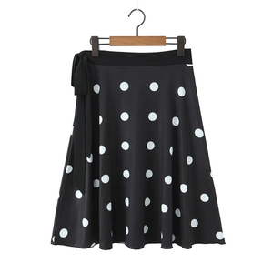 Détail d'une jupe trapèze noire à pois avec un nœud décoratif élégant à la taille