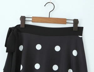 Vue détaillée de la jupe à pois avec nœud décoratif noir et taille haute ajustée élégante