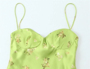 Detailed macro view of green floral satin dress with thin straps and cup support detail