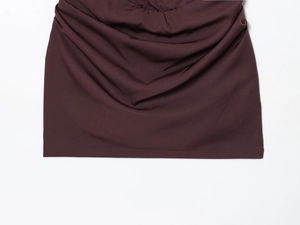 Detail der gerafften Taille und des strukturierten Stoffes dieses eng anliegenden Midikleids