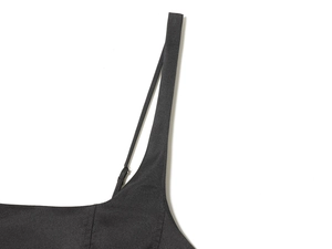 Detail of adjustable double shoulder straps and silver metal buckle on a black dress