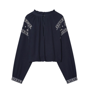 Detail of navy blue blouse showing ruffled collar and white ethnic floral embroidery