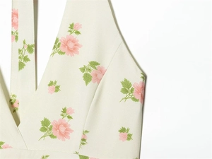 Detailansicht eines Neckholder-Tops mit V-Ausschnitt und rosa Blumendruck auf Creme