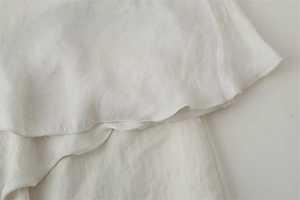 Detail der weißen Chiffon-Rüschen mit ordentlicher Overlock-Naht und weicher Textur
