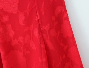 Close-up of red floral jacquard fabric texture on a slim fit summer sleeveless dress
