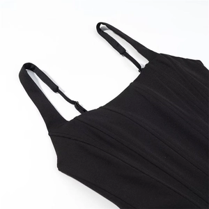Detail of corset-style dress with vertical stitching and adjustable straps on black fabric