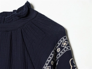 Detailed view of ruffle collar and ethnic embroidery on navy blue cotton blouse
