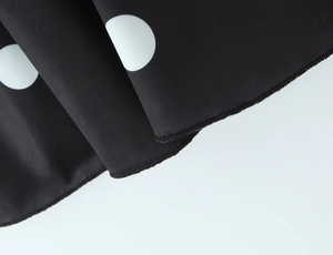 Détail du tissu à pois noirs et blancs avec des coutures de haute qualité et texture