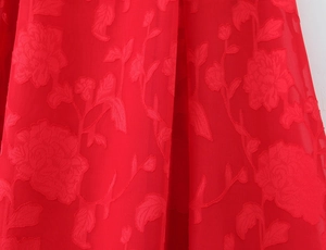 Detail of red floral jacquard fabric with elegant peony patterns on summer dress
