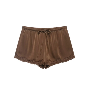 Detailed view of dark brown satin shorts featuring lace trim and a delicate drawstring bow