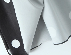Détail du tissu à pois noirs et blancs avec une finition de surjetage de haute qualité