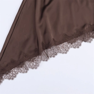 Detailed view of dark brown satin fabric with intricate scalloped lace trim on the hem