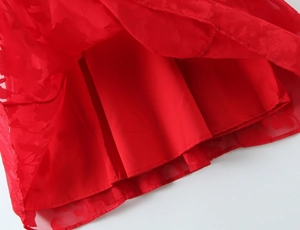 Detail of red floral burnout fabric and solid lining on the summer dress hemline