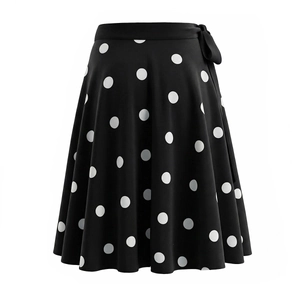 Détail de la jupe trapèze noire à pois blancs avec un nœud décoratif à la taille