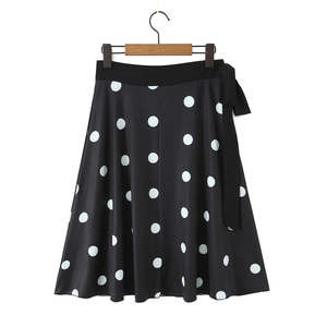 Détail de la jupe midi noire à pois blancs avec nœud à la taille et coupe évasée en A
