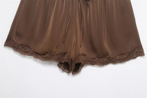 Detail of silk satin shorts in chocolate brown with delicate lace trim and drawstring