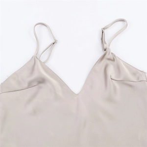 Detail of adjustable straps and silk satin fabric on champagne V-neck camisole top
