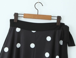 Détail de la taille de jupe à pois avec bande noire élégante et nœud décoratif latéral